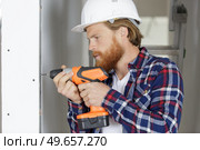 happy man drills a wall with a drill. Стоковое фото, агентство Ingram Publishing / Фотобанк Лори