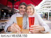 senior couple holding forwards their drinks on restaurant terrace. Стоковое фото, агентство Ingram Publishing / Фотобанк Лори