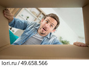 astonished man looking down into cardboard box. Стоковое фото, агентство Ingram Publishing / Фотобанк Лори
