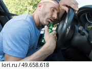 drunk man driving car and falling asleep at the wheel. Стоковое фото, агентство Ingram Publishing / Фотобанк Лори