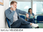 man using mobile phone in airport waiting area. Стоковое фото, агентство Ingram Publishing / Фотобанк Лори