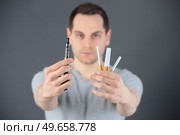 man holding an e-cig and cigarettes. Стоковое фото, агентство Ingram Publishing / Фотобанк Лори