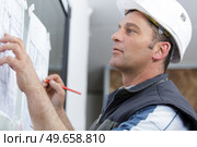 architect drawing against a wall. Стоковое фото, агентство Ingram Publishing / Фотобанк Лори