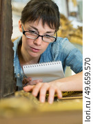 young female checking picture frame detail. Стоковое фото, агентство Ingram Publishing / Фотобанк Лори