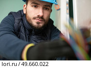 closeup of electrician engineer works with electric cables. Стоковое фото, агентство Ingram Publishing / Фотобанк Лори