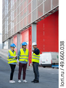 workers in high-visibility vests by loading bays. Стоковое фото, агентство Ingram Publishing / Фотобанк Лори