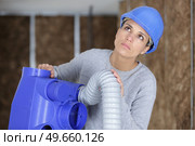 female electrician installing ventilation in ceiling. Стоковое фото, агентство Ingram Publishing / Фотобанк Лори