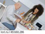 carer passing meal to elderly man wearing sling. Стоковое фото, агентство Ingram Publishing / Фотобанк Лори