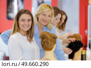portrait of a happy woman working with hair dummy. Стоковое фото, агентство Ingram Publishing / Фотобанк Лори