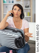 woman with suitcase on the telephone making questioning expression. Стоковое фото, агентство Ingram Publishing / Фотобанк Лори