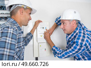 builder showing colleague how to control the heating. Стоковое фото, агентство Ingram Publishing / Фотобанк Лори