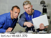 two men doing induction hardening in a factory. Стоковое фото, агентство Ingram Publishing / Фотобанк Лори