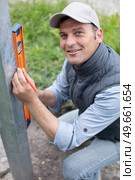 a handyman with sprit level. Стоковое фото, агентство Ingram Publishing / Фотобанк Лори