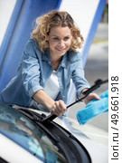 beautiful woman cleaning windscreen wipers. Стоковое фото, агентство Ingram Publishing / Фотобанк Лори