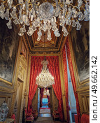 Beautiful decorated Napoleon apartments at Louvre palace. Royal family rooms with cardinal red curtains, golden ornate walls, paintings and crystal chandeliers suspended from ceiling. Стоковое фото, агентство Ingram Publishing / Фотобанк Лори