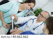 doctor bandaging patients leg in hospital. Стоковое фото, агентство Ingram Publishing / Фотобанк Лори