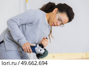 woman sanding a wood table with an electric sander. Стоковое фото, агентство Ingram Publishing / Фотобанк Лори
