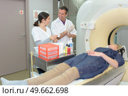 doctor giving instructions to technician for carrying out mri scan. Стоковое фото, агентство Ingram Publishing / Фотобанк Лори