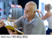 elderly man reading magazine in a bistro. Стоковое фото, агентство Ingram Publishing / Фотобанк Лори