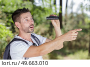 man in countryside with binoculars looking shocked and pointing. Стоковое фото, агентство Ingram Publishing / Фотобанк Лори