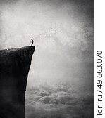 Freedom and liberty conceptual scene. Man on the edge of a cliff self liberating from fears and doubts as a flock of birds escape his body and fly free in the air. Surreal and inspirational art. Стоковое фото, агентство Ingram Publishing / Фотобанк Лори