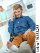 Sitting man with an ankle sprain. Стоковое фото, агентство Ingram Publishing / Фотобанк Лори