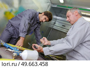 Men in paint spraying area. Стоковое фото, агентство Ingram Publishing / Фотобанк Лори