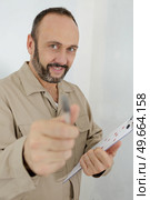 construction worker holding pen and clipboard ready for a signature. Стоковое фото, агентство Ingram Publishing / Фотобанк Лори
