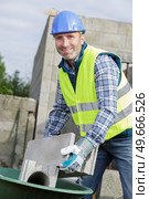 builder charging a construction wheelbarrows. Стоковое фото, агентство Ingram Publishing / Фотобанк Лори