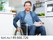 disabled young man preparing dinner in the kitchen. Стоковое фото, агентство Ingram Publishing / Фотобанк Лори