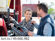 woman operating controls on side of lorry. Стоковое фото, агентство Ingram Publishing / Фотобанк Лори