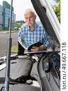 elder man servicing his car at home. Стоковое фото, агентство Ingram Publishing / Фотобанк Лори