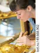 female artisan working with gold leaf. Стоковое фото, агентство Ingram Publishing / Фотобанк Лори