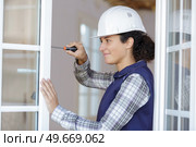 young woman unscrews the fixing screws of the window handle. Стоковое фото, агентство Ingram Publishing / Фотобанк Лори