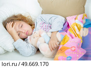 Young girl lying down holding head. Стоковое фото, агентство Ingram Publishing / Фотобанк Лори