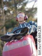 resting on the tractor mower. Стоковое фото, агентство Ingram Publishing / Фотобанк Лори