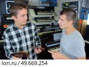 young men choosing music in a musical shop. Стоковое фото, агентство Ingram Publishing / Фотобанк Лори