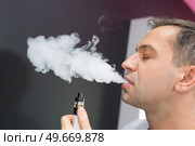 man using vapourizer as smoking alternative. Стоковое фото, агентство Ingram Publishing / Фотобанк Лори
