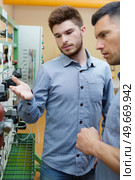 portrait of a young man inspecting gauges. Стоковое фото, агентство Ingram Publishing / Фотобанк Лори