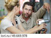 supervisor questioning female mechanic using pneumatic impact wrench. Стоковое фото, агентство Ingram Publishing / Фотобанк Лори