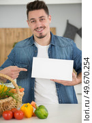 nutritionist showing a blank banner in the kitchen. Стоковое фото, агентство Ingram Publishing / Фотобанк Лори