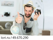 man indicating enough savings in piggybank for a holiday. Стоковое фото, агентство Ingram Publishing / Фотобанк Лори