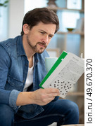 man doing crosswords at home. Стоковое фото, агентство Ingram Publishing / Фотобанк Лори