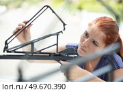woman fastening roof bar fixation for bicycle. Стоковое фото, агентство Ingram Publishing / Фотобанк Лори