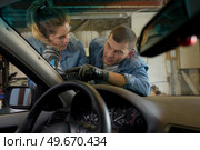 a man and woman changing windshield. Стоковое фото, агентство Ingram Publishing / Фотобанк Лори
