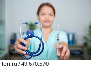 nurse holding tools of her profession stethoscope and syringe. Стоковое фото, агентство Ingram Publishing / Фотобанк Лори