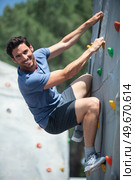man climber on artificial climbing wall in bouldering gym. Стоковое фото, агентство Ingram Publishing / Фотобанк Лори