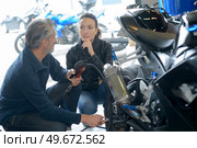 man and woman checking motorbike in workshop. Стоковое фото, агентство Ingram Publishing / Фотобанк Лори