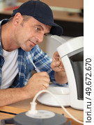 mature man repairing broken coffee machine. Стоковое фото, агентство Ingram Publishing / Фотобанк Лори