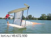 salior trying to right his catamaran after capsize. Стоковое фото, агентство Ingram Publishing / Фотобанк Лори